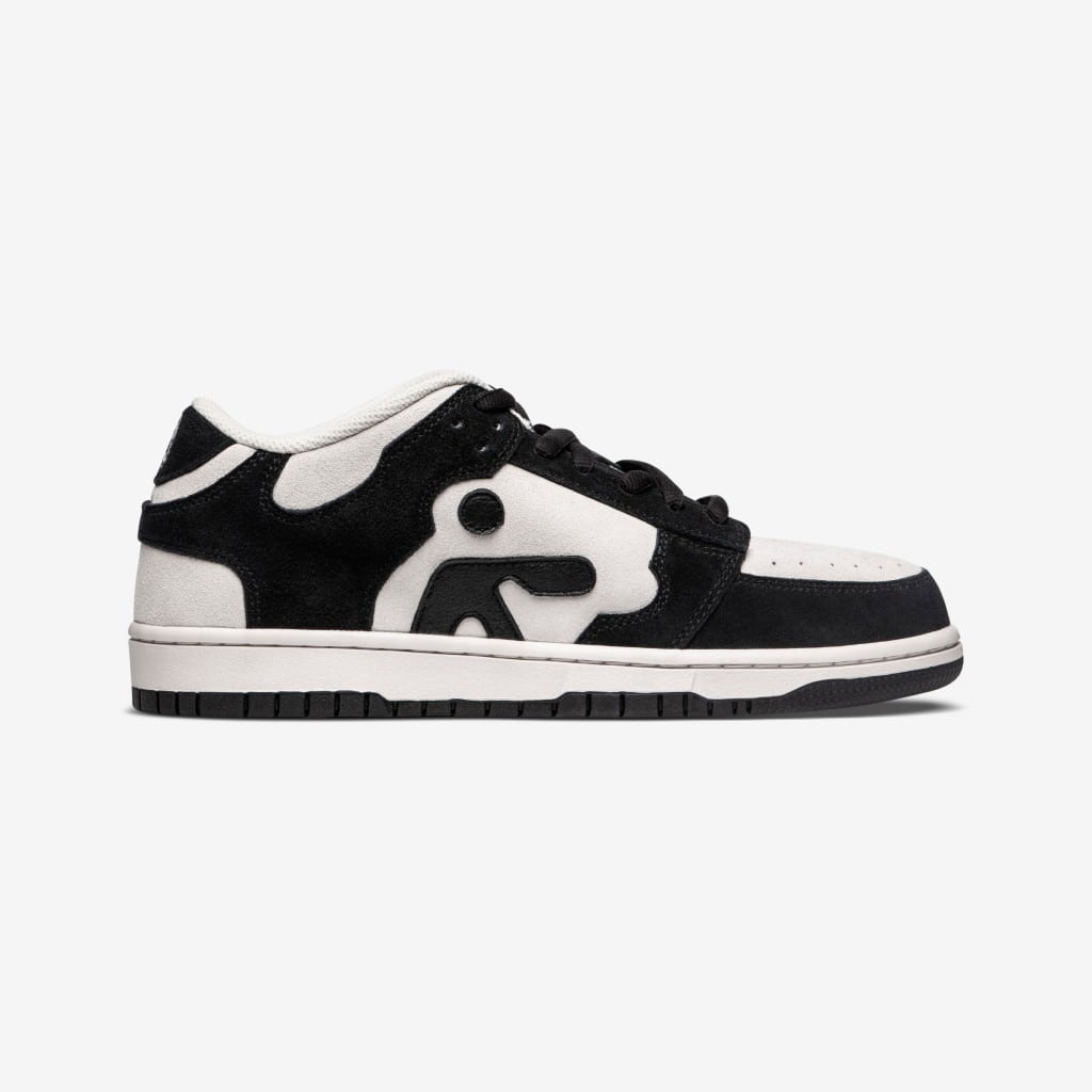 Black and white low-top sneakers with bold letter design.