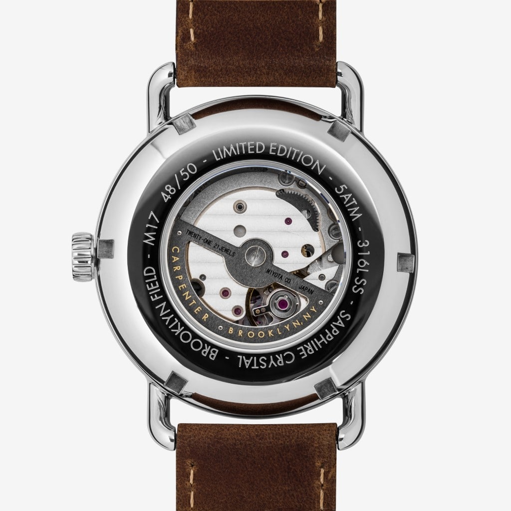Close-up product photography of mechanical wristwatch showing transparent case back and movement details